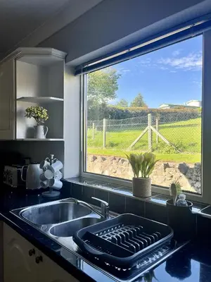 a kitchen with a sink and a large window at Ty Newydd in Llangyniew