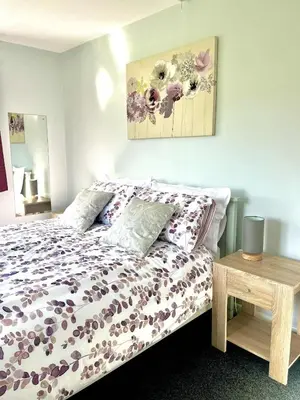 a bedroom with a bed with flowers on it at Ty Newydd in Llangyniew