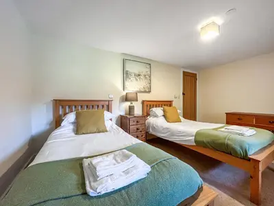 two beds sitting next to each other in a bedroom at Granary - Uk50617 in Corwen