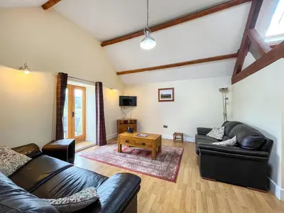 a living room with two leather couches and a table at Granary - Uk50617 in Corwen