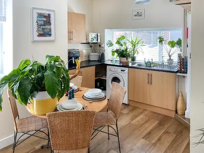 a kitchen with a table and chairs and a kitchen with a plant at Kookaburra Lodge in Brecon