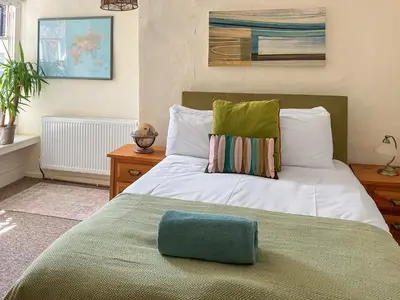 a bed with a green pillow on top of it at Kookaburra Lodge in Brecon