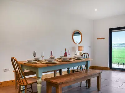 a dining room with a table and chairs at Acre Luxury Lodges-Cedar Lodge in Evenjobb