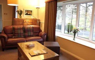 a living room with a couch and a window at Macdonald Plas Talgarth Resort in Aberdyfi