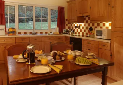 a kitchen with a wooden table with food on it at Macdonald Plas Talgarth Resort in Aberdyfi