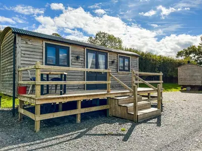 a wooden cabin with a staircase and a deck at Blodwen - Ukc7016 in Corwen
