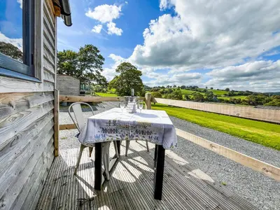 a table on the porch of a house at Blodwen - Ukc7016 in Corwen