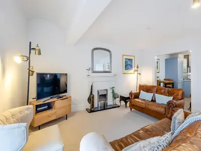 a living room with a couch and a tv at The Penthouse Westhaven in Aberdyfi