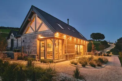 a wooden cabin with a black roof at Hay Barn in Trefeglwys
