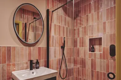 a bathroom with a shower with a sink and a mirror at Hay Barn in Trefeglwys