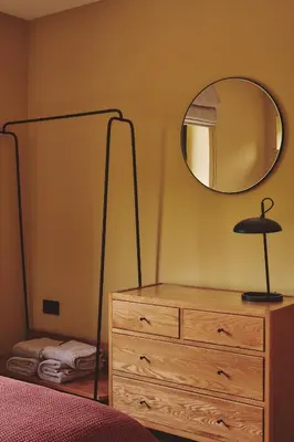 a bedroom with a dresser and a mirror at Hay Barn in Trefeglwys