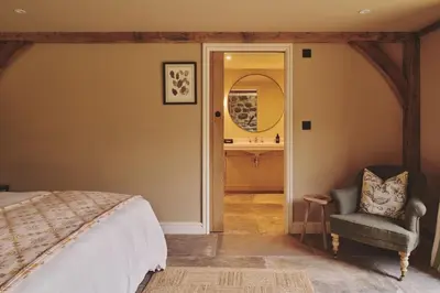 a bedroom with a bed and a chair and a sink at Mill House in Trefeglwys