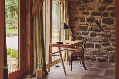 a wooden desk with a chair next to a window at Mill House in Trefeglwys
