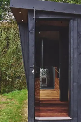 a black house with a tv inside of it at Mill House in Trefeglwys