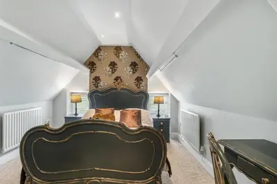 a bedroom with a large bed in a attic at The Topiary by Birch Stays in Wollaston