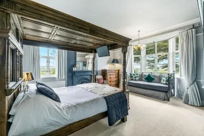 a bedroom with a large bed and a large window at The Topiary by Birch Stays in Wollaston