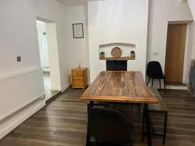 a dining room with a wooden table and chairs at Llangollen - House - Sleeps 8- Garden in Llangollen