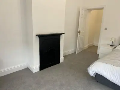 a bedroom with a black cabinet next to a bed at Llangollen - House - Sleeps 8- Garden in Llangollen