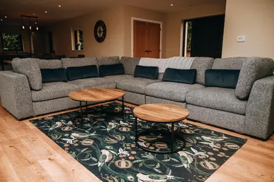 a living room with a couch and two tables on a rug at Beacons View Luxury Lakeside Chalet- Trem Y Fan in Brecon