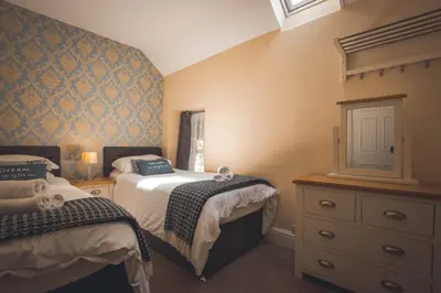 a small bedroom with two beds and a dresser at Noddfa Country House in Harlech