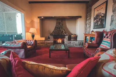 a living room with a fireplace and couches at Noddfa Country House in Harlech
