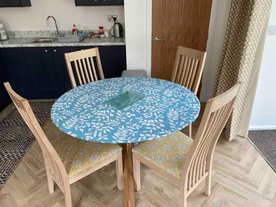 a dining room table with four chairs and a blue at Serene Llanbedr Retreat with Garden View in Llanbedr