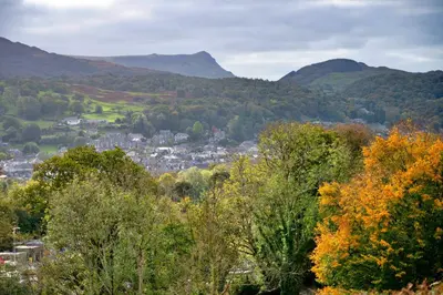 a town in the hills with mountains in the background at Finest Retreats - Pandy Farmhouse in Dolgellau