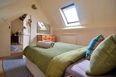 a bedroom with a large bed in a attic at Finest Retreats - Pandy Farmhouse in Dolgellau