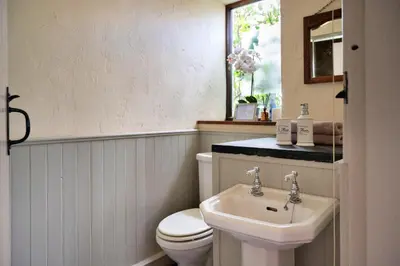 a bathroom with a white toilet and a sink at Finest Retreats - Pandy Farmhouse in Dolgellau
