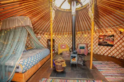 a room with a bed and chairs in a yurt at Finest Retreats - Pandy Traditional Yurt in Dolgellau