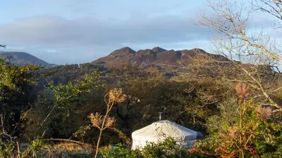 a church with a mountain in the background at Finest Retreats - Pandy Traditional Yurt in Dolgellau