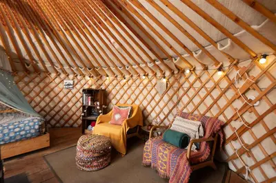 a room with two chairs and a bed in a yurt at Finest Retreats - Pandy Traditional Yurt in Dolgellau