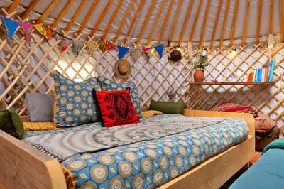 a bed in a yurt with pillows and flags at Finest Retreats - Pandy Mongolian Yurt in Dolgellau
