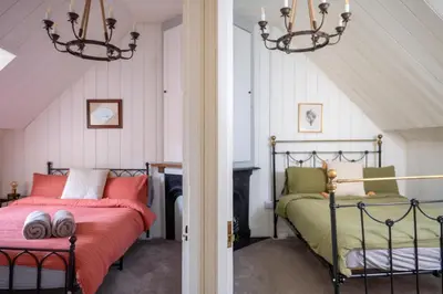 a attic bedroom with two beds and a chandelier at Finest Retreats - Waen Fechan in Dolgellau