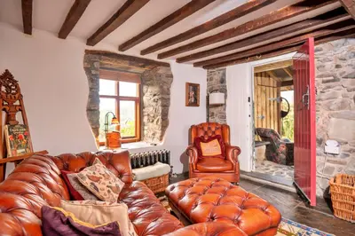 a living room with a leather couch and a chair at Finest Retreats - Waen Fechan in Dolgellau