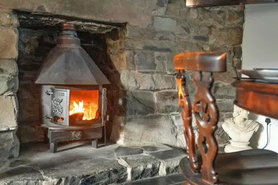 a stone fireplace with a stove in a room at Finest Retreats - Waen Fechan in Dolgellau