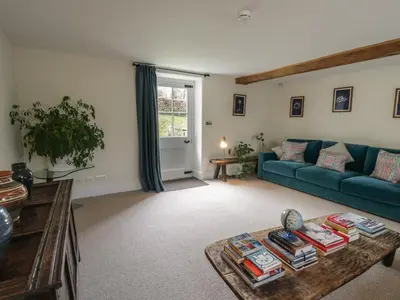 a living room with a blue couch and a table at West Cottage in Llandovery