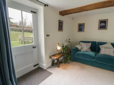 a living room with a blue couch and a window at West Cottage in Llandovery