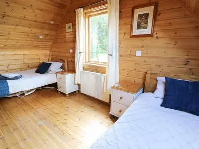 a bedroom with two beds in a wooden cabin at Pen Y Clawdd in Presteigne