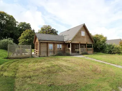 a wooden house on a field with a yard at Dan Y Coed in Presteigne