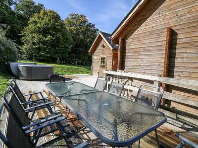a patio with a table and chairs on a deck at Dan Y Coed in Presteigne