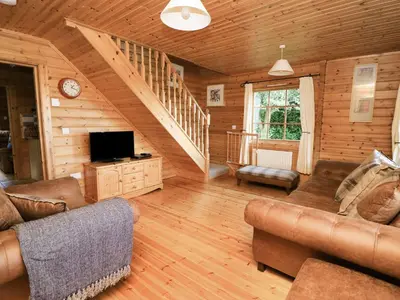 a living room with a couch and a tv at Dan Y Coed in Presteigne