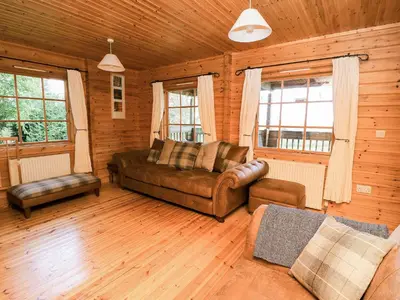 a living room with a couch and a chair at Dan Y Coed in Presteigne