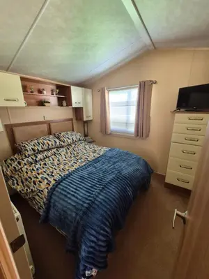 a small bedroom with a bed and a window at The Dancing Dolphin, 124 Aber Bay Holiday Park, Clarach, Aberystwyth in Aberystwyth
