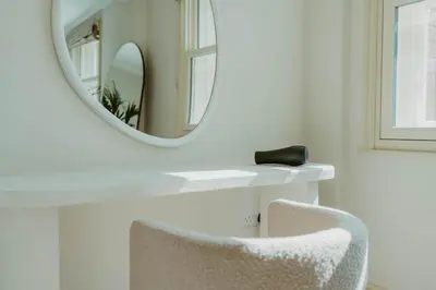 a mirror over a white table with a chair at The Catnap Suite in Shrewsbury
