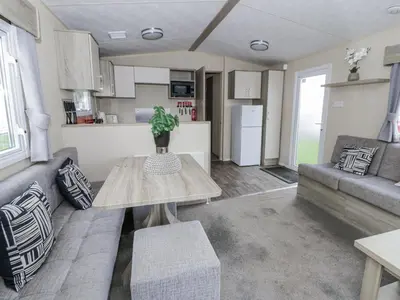 a living room with a couch and a table at Brynowen Holiday Park - 22432 in Borth