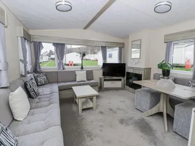 a living room with a couch and a tv at Brynowen Holiday Park - 22432 in Borth