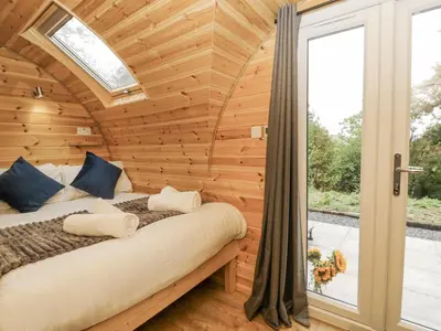 a bed in a wooden room with a window at Oak View in Rhayader