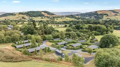an aerial view of a farm with trees and a road at Oak View in Rhayader