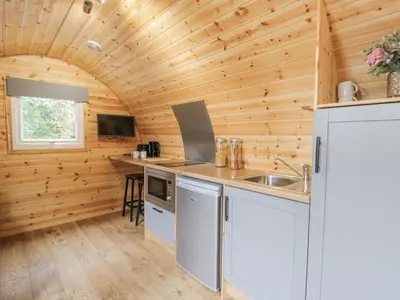 a kitchen in a log cabin with a sink at Oak View in Rhayader
